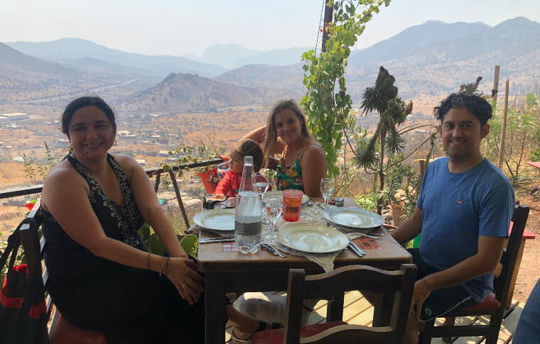 Two women and a man enjoying a meal and stunning view